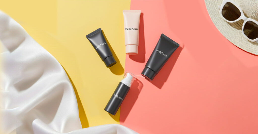 “BelleNora-branded Korean-style sunscreen bottles on a pastel background with summer accessories, representing dermatologist-approved skincare.”